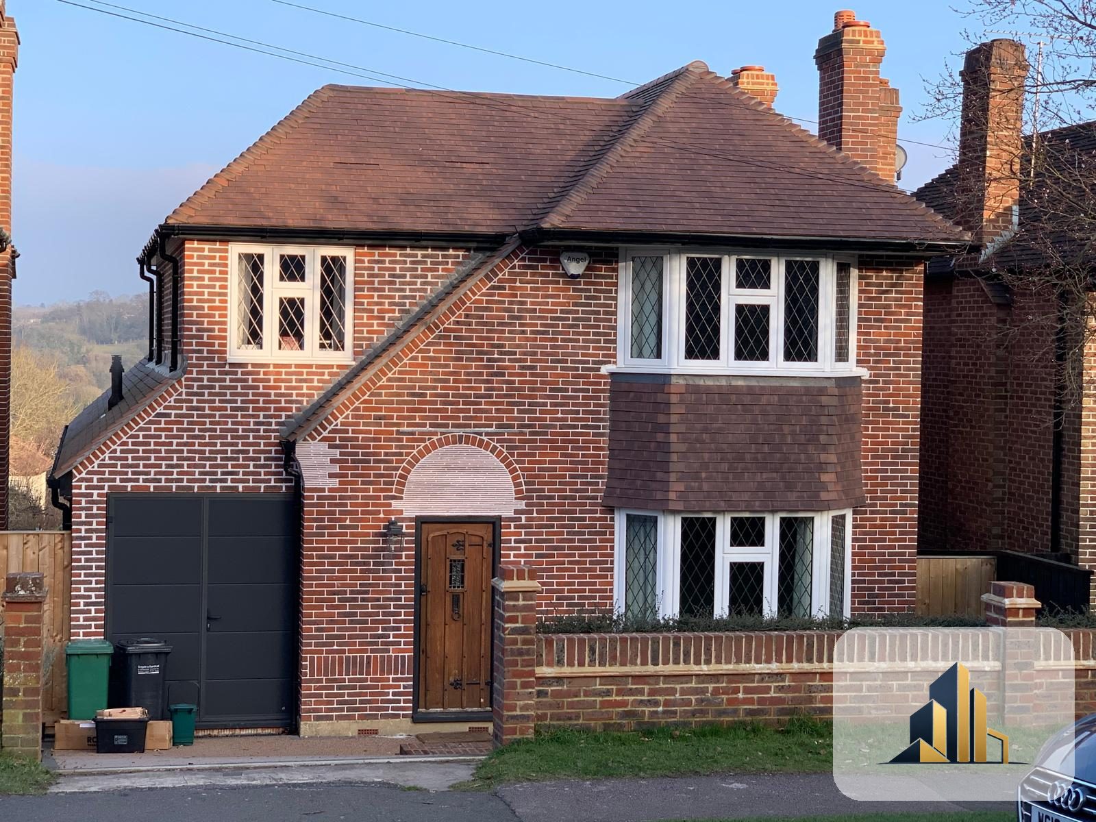 Completed two-storey side extension with integral garage, matched brick and roof, Banstead