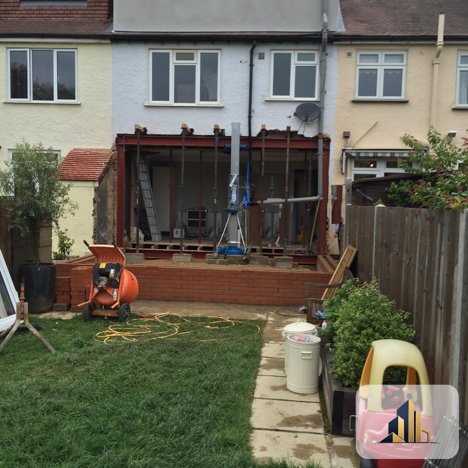 Rear of a Motspur Park house opened up with a steel goal-post frame and acrow props during the extension