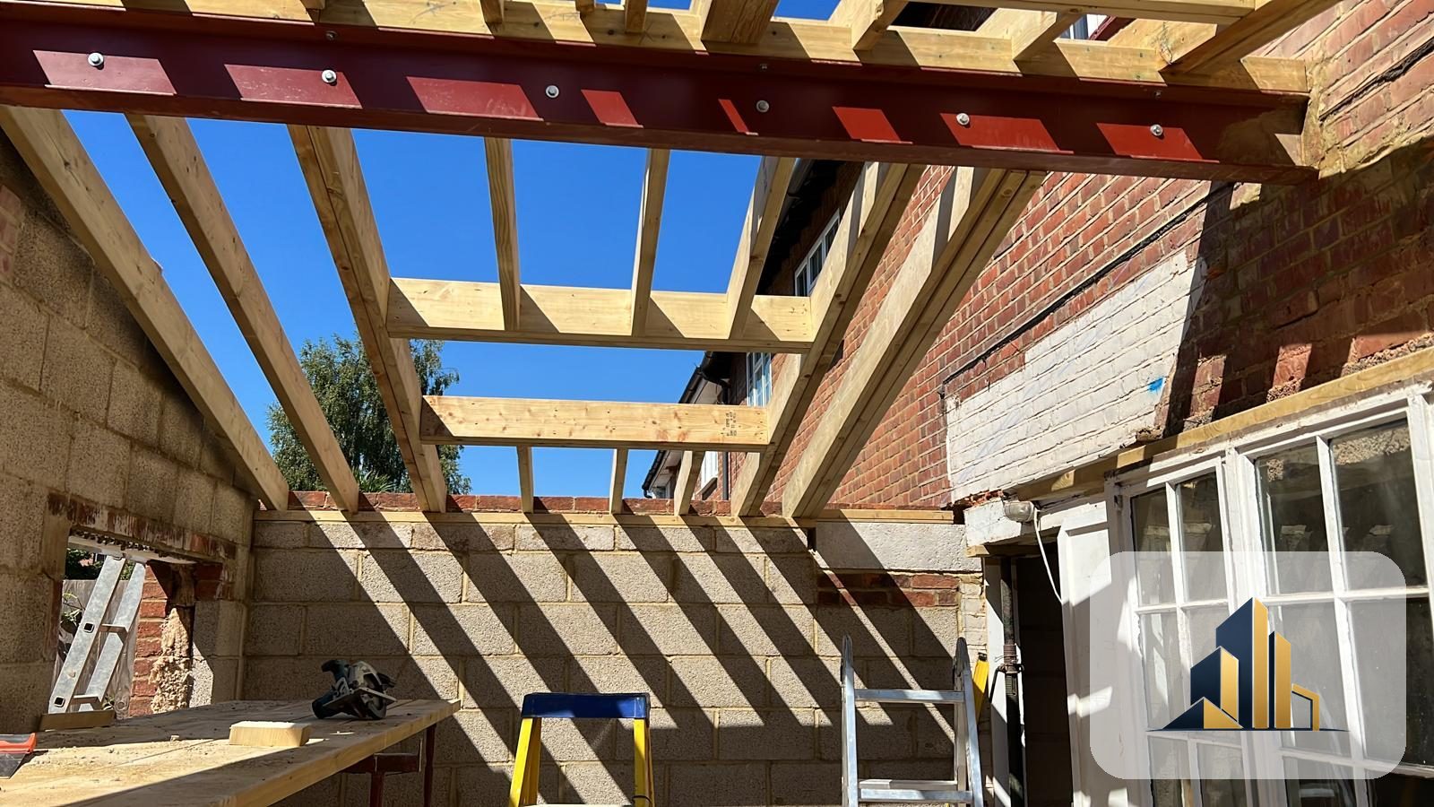 New steel beam and timber roof rafters framing the sloped roof of a Richmond extension